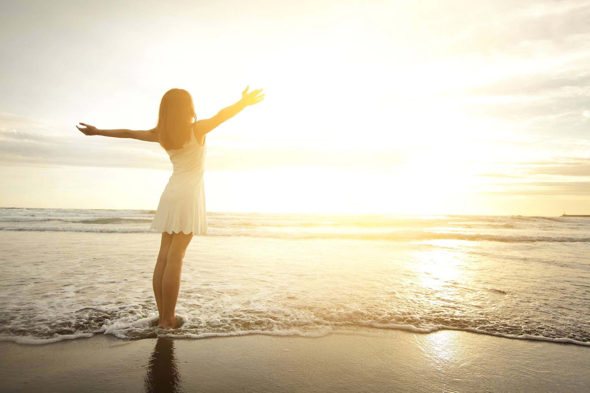 frau bei sonnenaufgang am meeresstrand