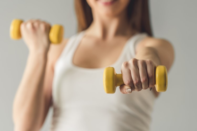 Frau macht Hanteltraining